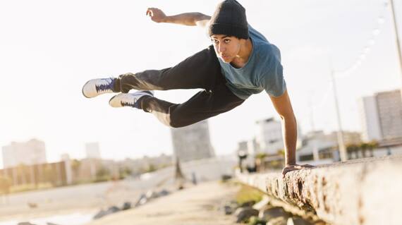 Free running athlete in the streets and beach of Barcelona. Parkour